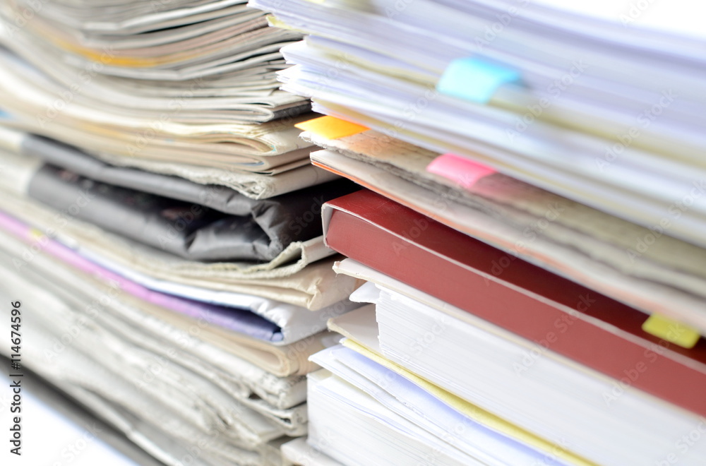 Stack of newspaper and documents with high key tone and blur focus,close-up of newspaper and documents on desk at business office. Stack of newspaper and documents with high key tone and blur focus,close-up of newspaper and documents on desk at business office.