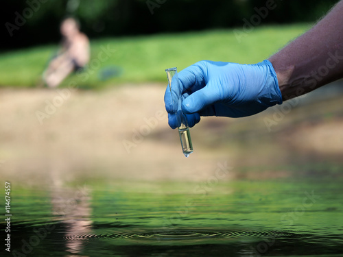 Hand in glove holding a test tube