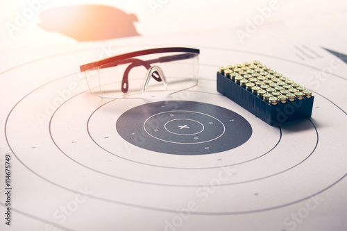 x on paper target with safety glasses and bullet with flare and