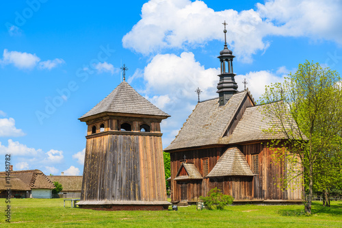 Old wooden church on green meadow in Tokarnia village, Poland
