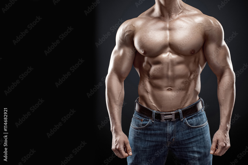 Fototapeta premium Muscular bodybuilder guy doing posing over black background