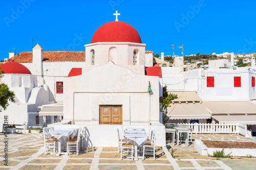 A view of typical church building on square with taverna tables in Mykonos town, Cyclades islands, Greece
