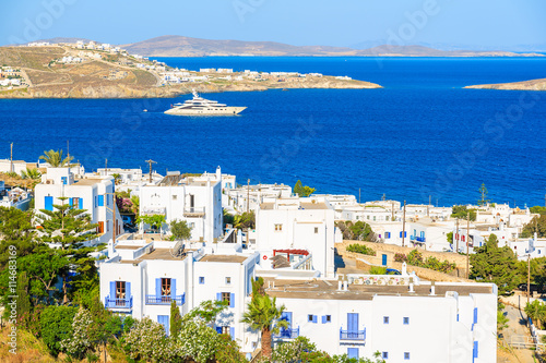 Fototapeta Naklejka Na Ścianę i Meble -  A view of typical Greek apartment buildings in Mykonos town with sea in background, Cyclades islands, Greece