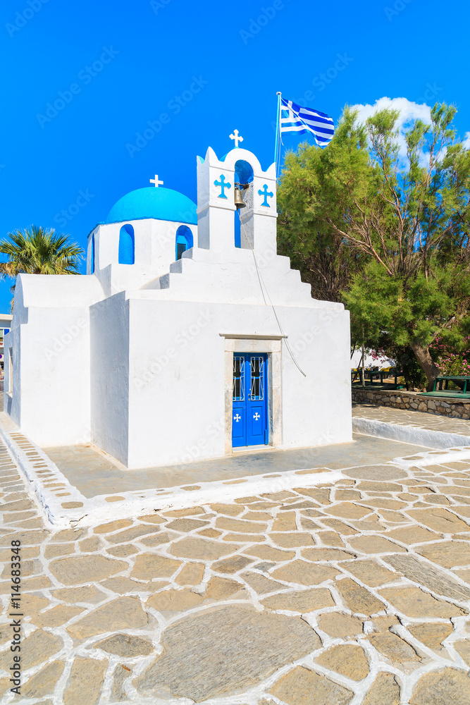 Square with typical white church with blue dome and Greek flag on Paros island, Cyclades, Greece