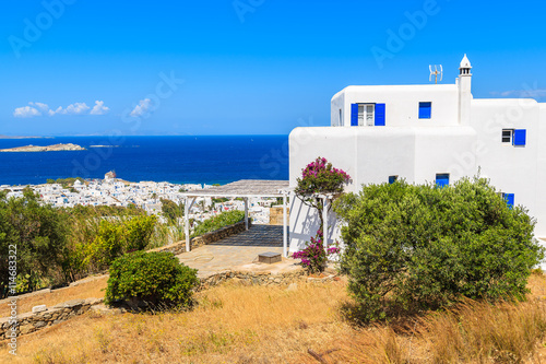 Typical Greek house on coast of Mykonos island with town and sea in background, Cyclades islands, Greece