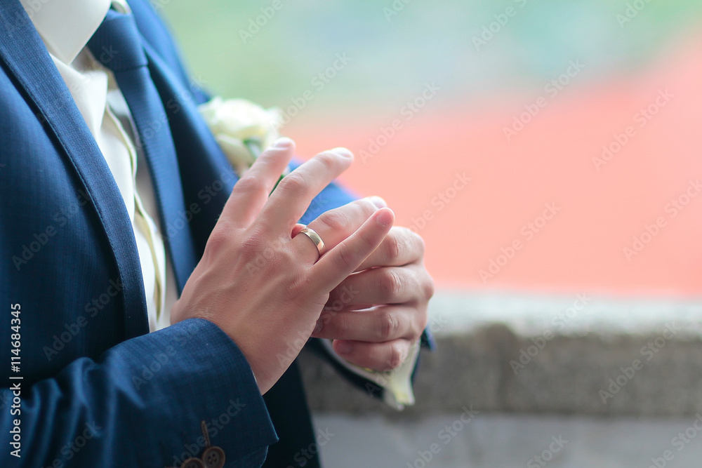 Fototapeta premium Groom touches wedding ring