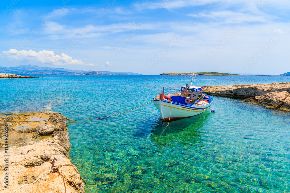 A fishing boat on in small sea bay with crystal clear turquoise water, Paros island, Greece