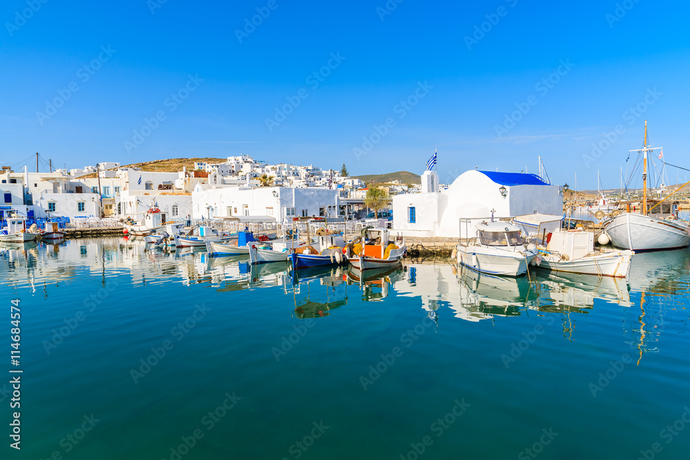 A view of Naoussa port with Greek style church and traditional fishing boats, Paros island, Cyclades, Greece