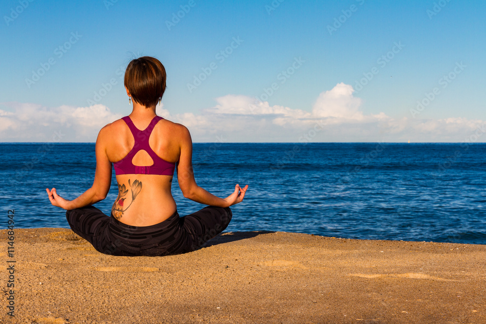 Young woman makes Yoga on a Beach