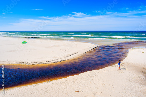 A view of white sand beach and Plasnica river estuary to Baltic Sea, Debki coastal village, Poland photo