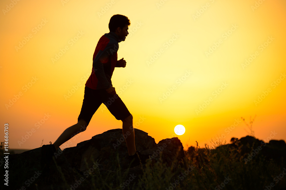 Young Sportsman Running on the Rocky Mountain Trail at Sunset. Active Lifestyle Young Sportsman Running on the Rocky Mountain Trail at Sunset. Active Lifestyle