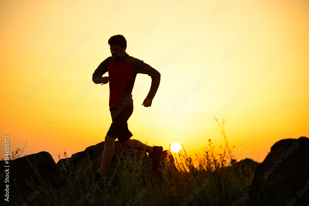 Young Sportsman Running on the Rocky Mountain Trail at Sunset. Active Lifestyle Young Sportsman Running on the Rocky Mountain Trail at Sunset. Active Lifestyle