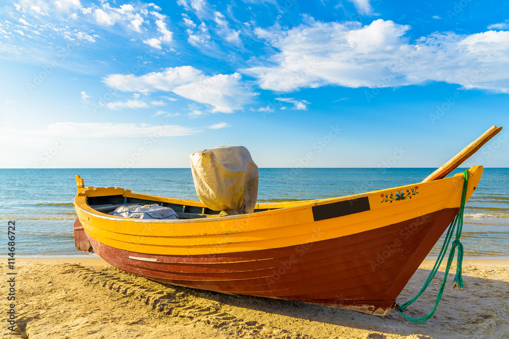 Typical fishing boat on a beach in Debki coastal village at sunset time, Baltic Sea, Poland