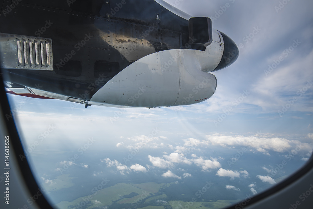 Clouds, screw, sky as seen in window of an aircraft Clouds, screw, sky as seen in window of an aircraft