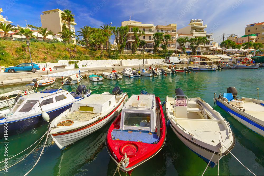 Obraz premium Fishing boat and wharf of Chania in sunny summer day, Crete, Greece