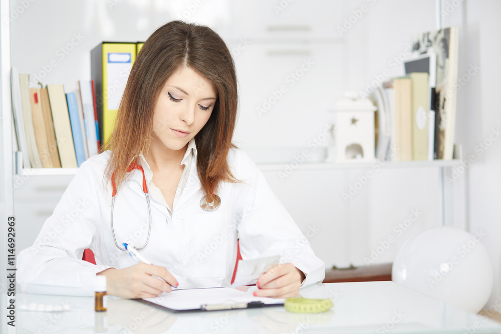 smiling doctor woman holding pills in office