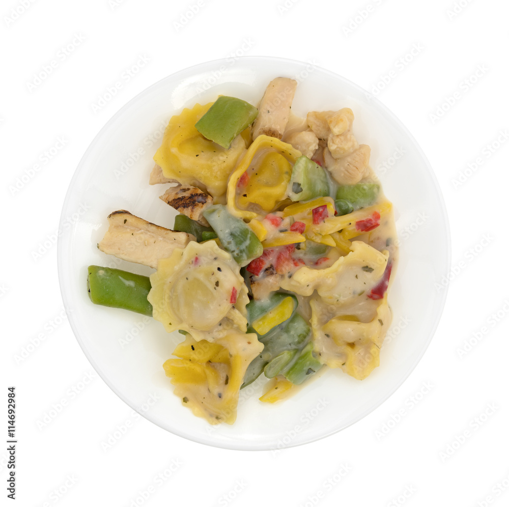 Chicken and tortellini TV dinner on a white plate isolated on a white background top view. Chicken and tortellini TV dinner on a white plate isolated on a white background top view.