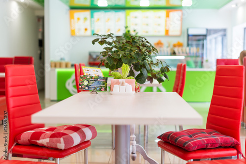 Modern design restaurant interior in white and red colors with plants.