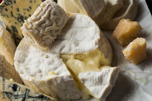 Cheese assorted on a table background. Variety sorts for appetizing, gourmet, delicious snacks. Traditional French dish for wine on lunch and dinner closeup. Camembert, Roquefort.
