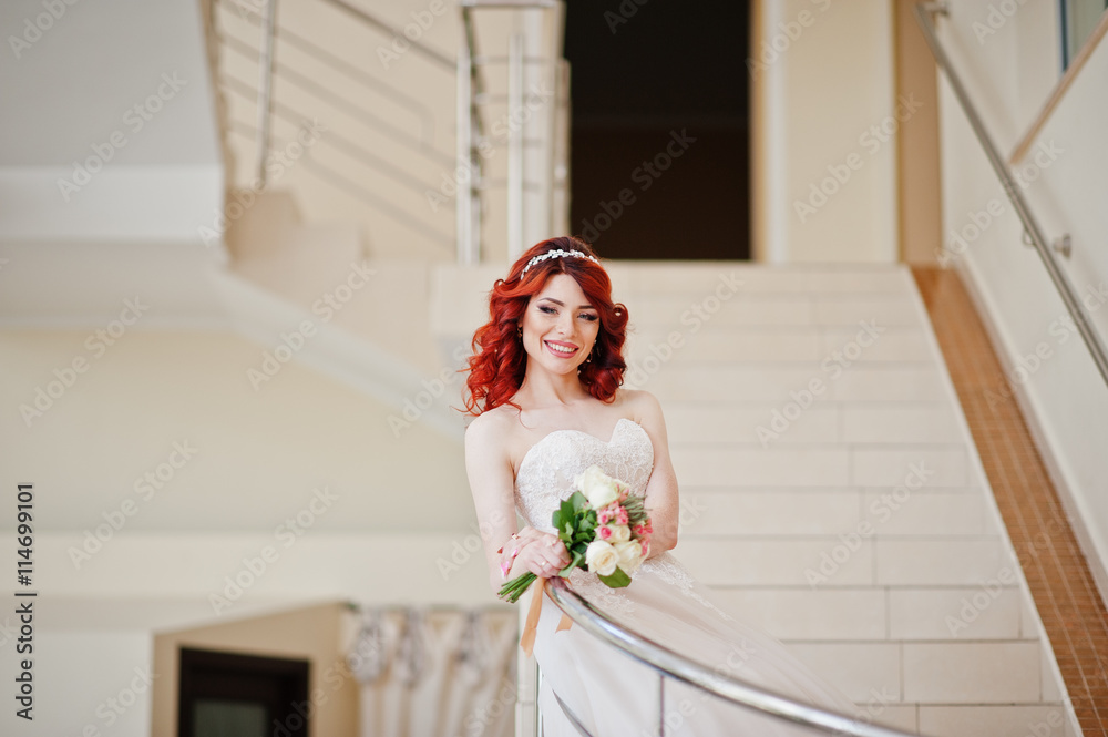 Charming red-haired bride with wedding bouquet at hand posed on Charming red-haired bride with wedding bouquet at hand posed on
