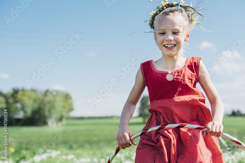 Happy girl with hula hoop wearing flower wreath photo