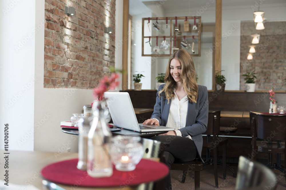 Young woman using laptop in a coffee shop Young woman using laptop in a coffee shop