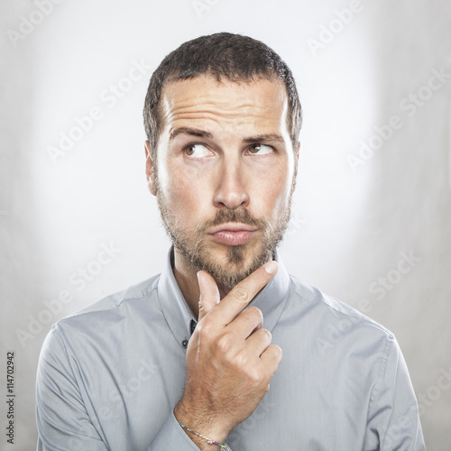 Portrait of handsome young thoughtful man isolated over white ba