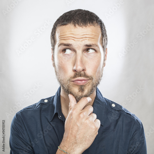 Portrait of handsome young thoughtful man isolated over white ba