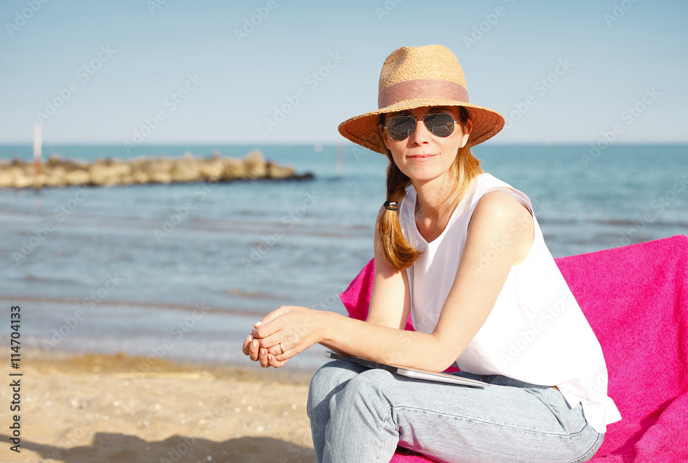 Happy middle age woman relaxing on the beach. 