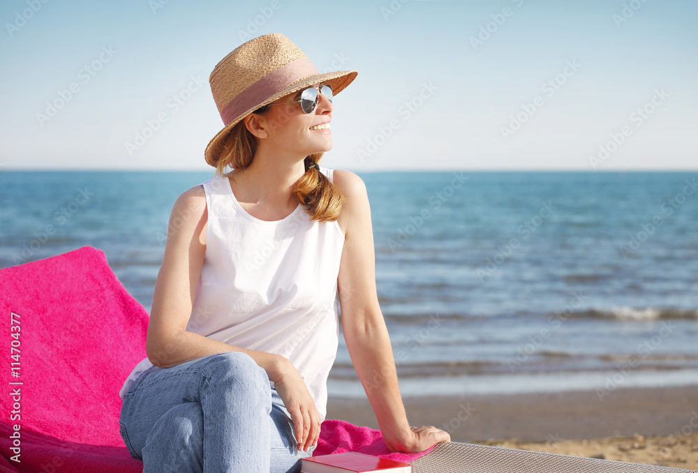 Ejoying summer on seaside. Beautiful woman relaxing on the beach.