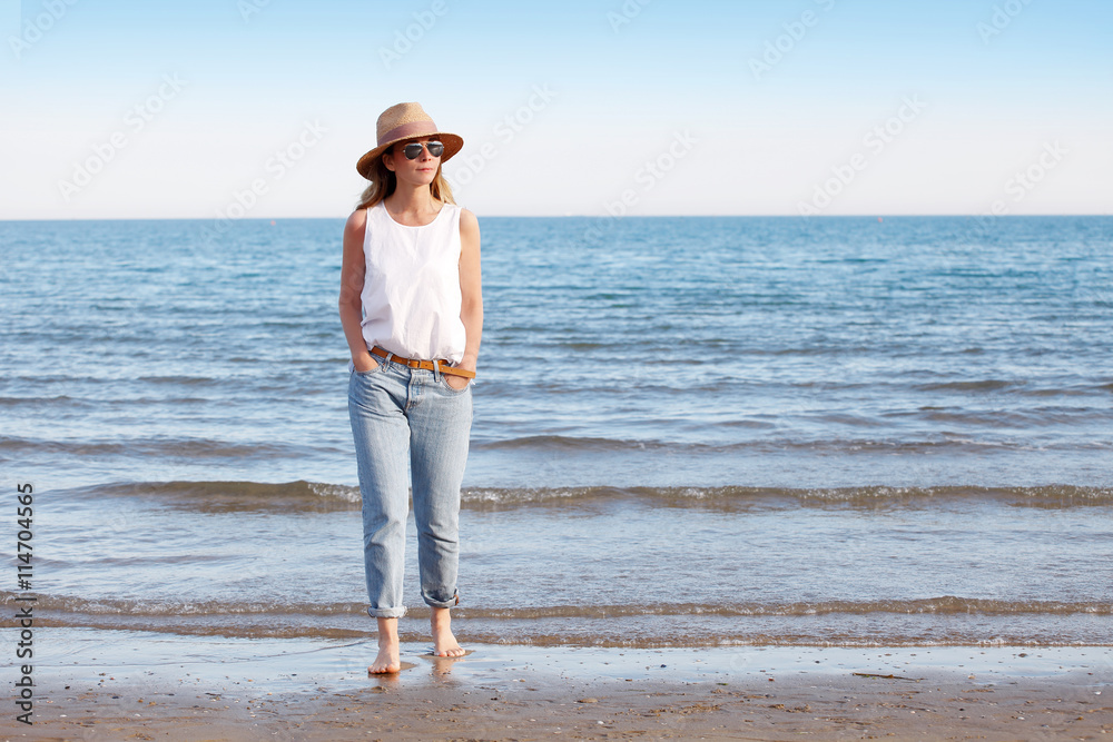Enjoying summer. Beautiful woman walking on beach in casual.