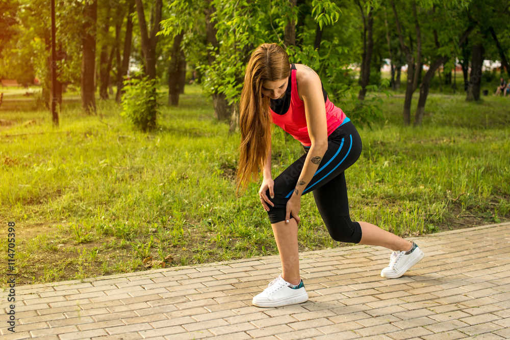 Woman in pain while running in park Woman in pain while running in park