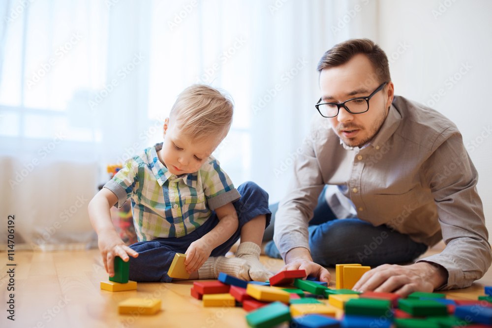 father and son playing with toy blocks at home