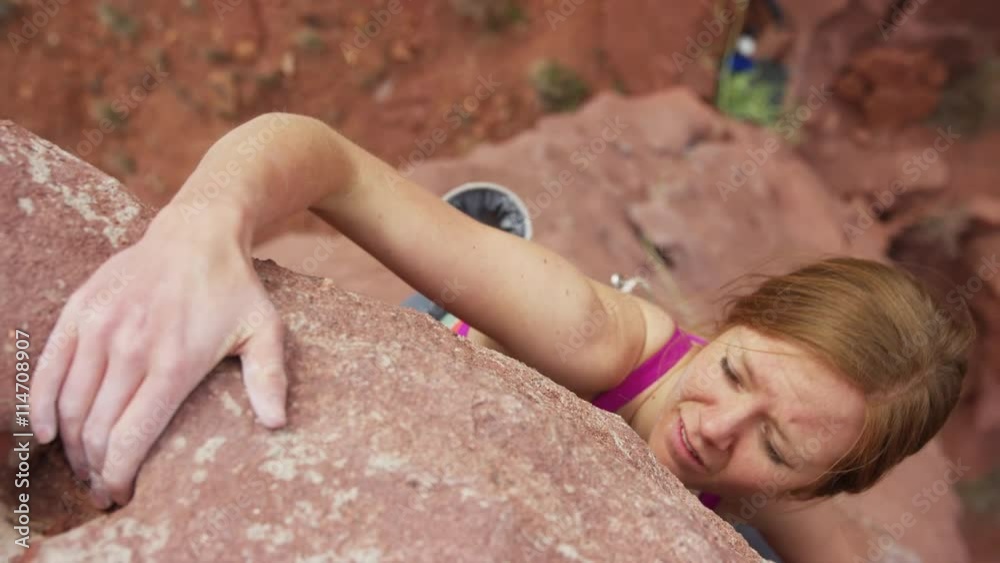 Medium high angle shot of climber reaching top of rock formation / Fisher Towers, Utah, United States
