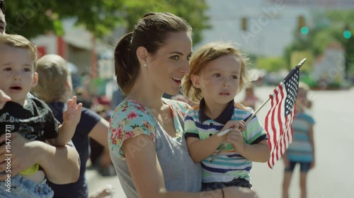 Medium slow motion shot of family watching parade / American Fork, Utah, United States
