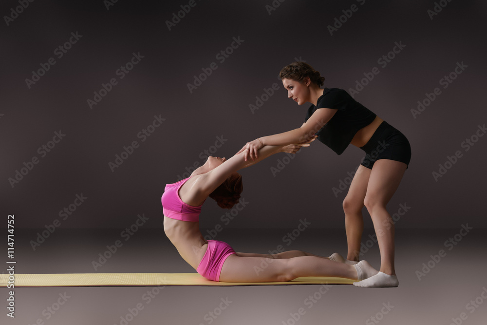 Photo of woman helping her friend do stretching Photo of woman helping her friend do stretching