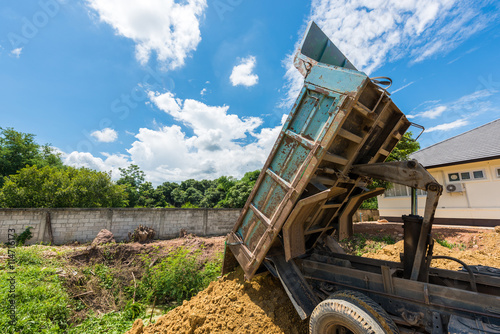 Dump truck unloading soil at construction site