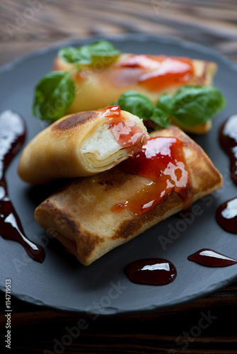Closeup of rolled crepes with cottage cheese stuffing and jam