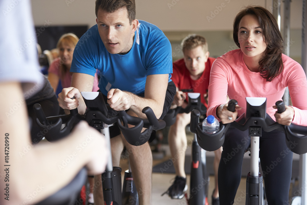 Spinning class on exercise bikes at a gym, close up Spinning class on exercise bikes at a gym, close up
