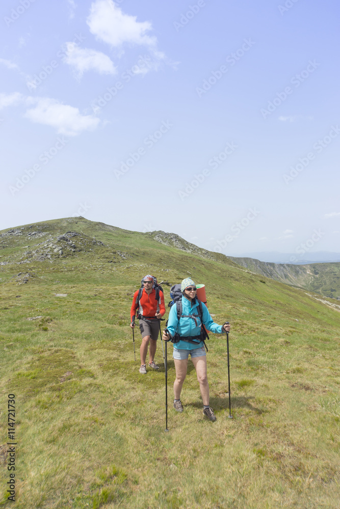 Obraz premium Summer hiking in the mountains with a backpack .
