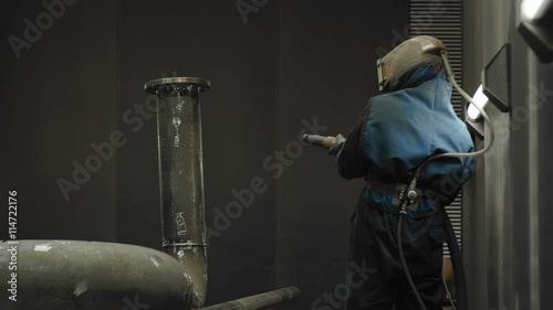 Worker Sandblasting Gas Pipe photo