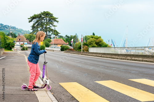 Pretty little girl is going to cross the road alone