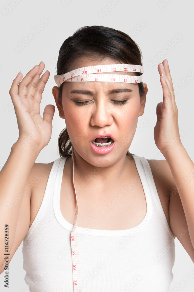Asian woman measuring his head, going crazy from dieting Asian woman measuring his head, going crazy from dieting