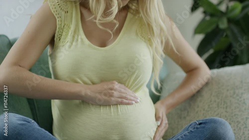 Close up slow motion shot of pregnant woman examining belly / Cedar Hills, Utah, United States