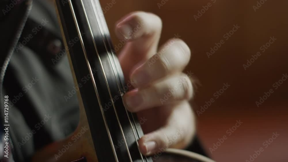 Close up shot of top hand playing cello in bar / Salt Lake City, Utah, United States Close up shot of top hand playing cello in bar / Salt Lake City, Utah, United States