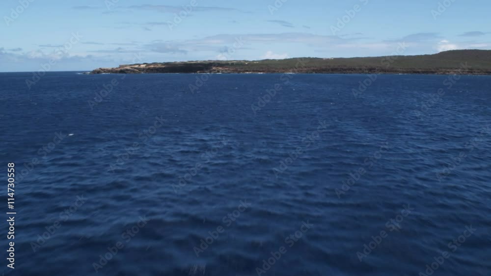 Fast flight over blue water toward the shore of Molokai Fast flight over blue water toward the shore of Molokai