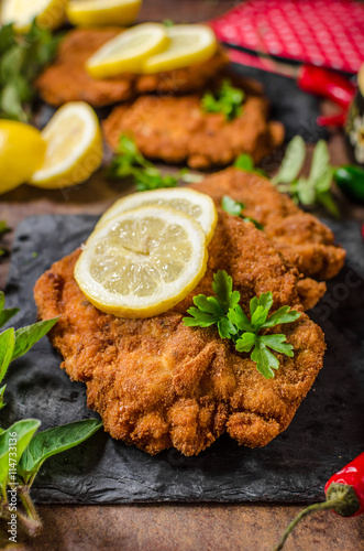 Schnitzel with fries, salad and herbs photo