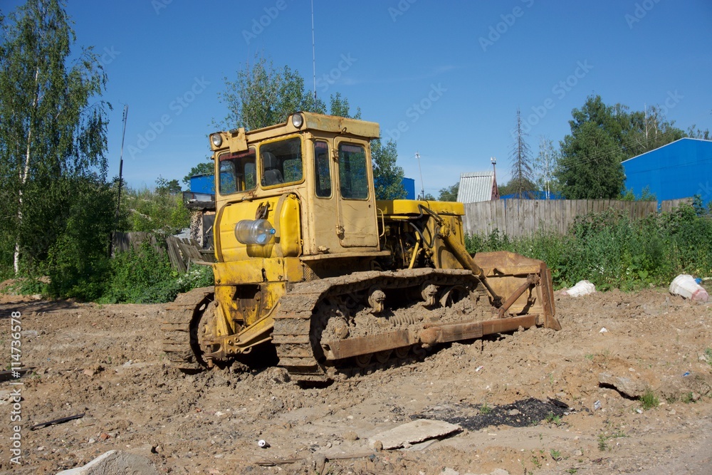 Yellow tractor in the mud