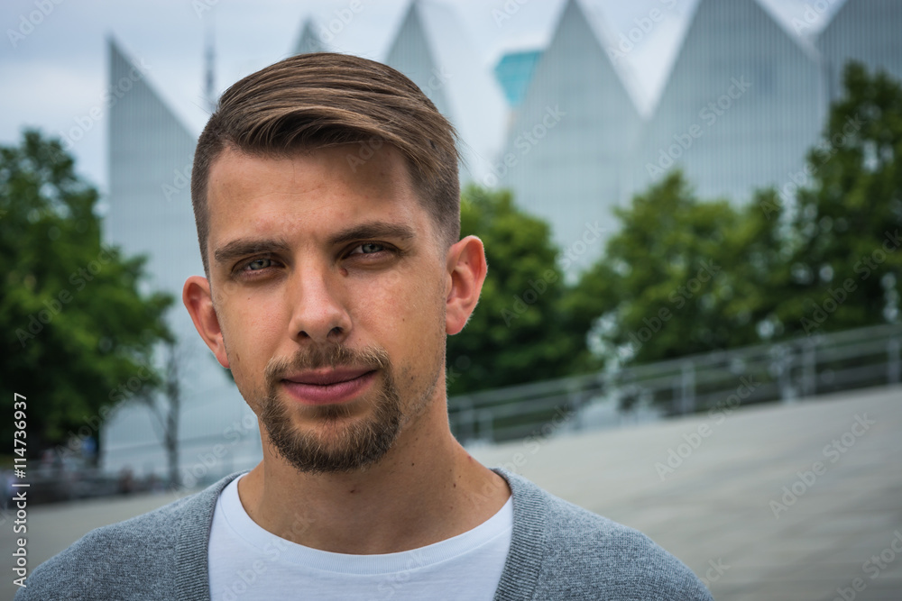 Young man with modern haircut with Philharmonic Hall in Szczecin in the background Young man with modern haircut with Philharmonic Hall in Szczecin in the background