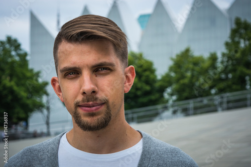 Εκτύπωση καμβά Young man with modern haircut with Philharmonic Hall in Szczecin in the backgrou